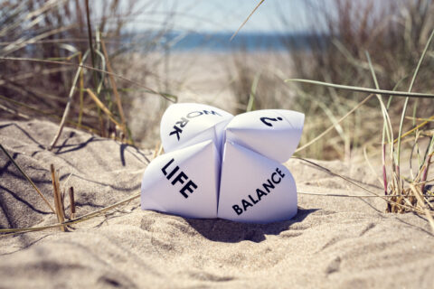 Origami fortune teller that reads work, life and balance on beach sand