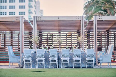 A silver-themed long table with white roses at the North Tower Lawn