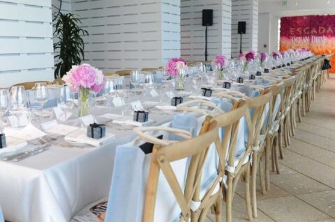 A long dining table, decorated with pink flowers, for a celebration at the Ocean Gallery