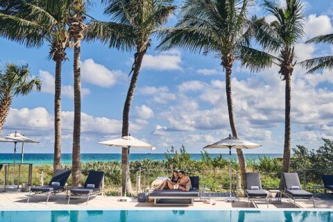 Carillon pool with palm trees and the ocean in the background