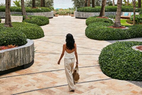 woman holding purse walking through exterior of carillon